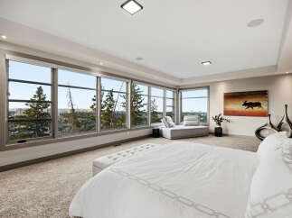 Experience breathtaking panoramic views from this luxurious master suite, featuring expansive windows that showcase the stunning landscape.