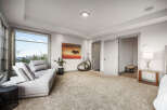 Experience luxury living in this spacious bedroom featuring a plush sectional sofa and a large window with breathtaking city views.