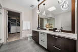 This modern bathroom features a spacious walk-in closet with ample shelving and drawers, perfect for organization.