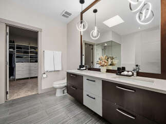 This modern bathroom features a spacious walk-in closet with ample shelving and drawers, perfect for organization.