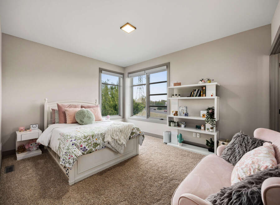 This charming bedroom features a cozy queen-size bed with a floral comforter and plush pillows, complemented by a white nightstand and a fluffy throw blanket.