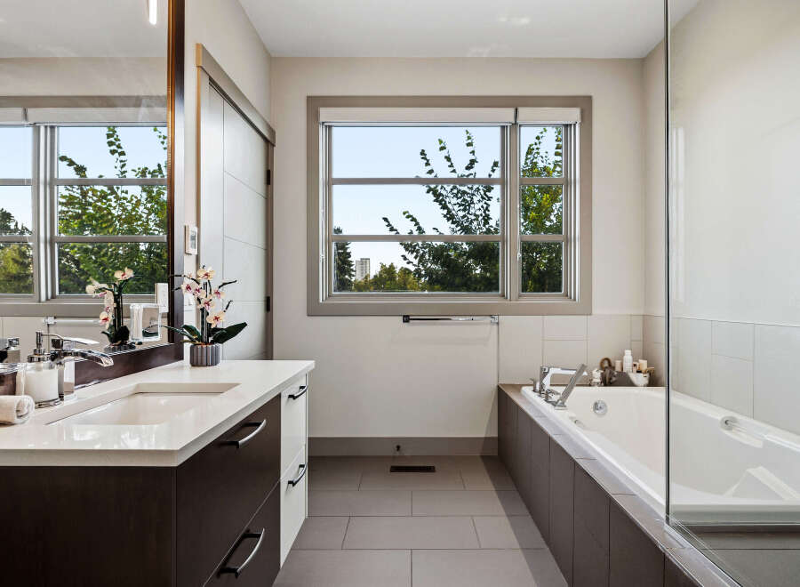Experience modern luxury in this stunning bathroom, featuring a sleek vanity with a double sink and ample storage.