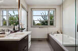 Experience modern luxury in this stunning bathroom, featuring a sleek vanity with a double sink and ample storage.