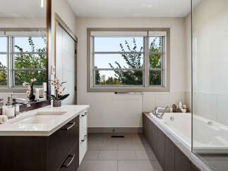 Experience modern luxury in this stunning bathroom, featuring a sleek vanity with a double sink and ample storage.