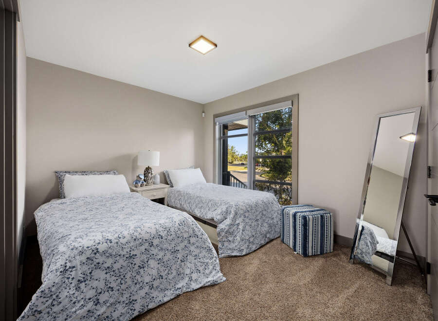 This charming bedroom features two twin beds with floral print comforters, perfect for guests or a shared space.