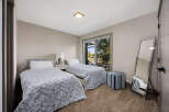 This charming bedroom features two twin beds with floral print comforters, perfect for guests or a shared space.