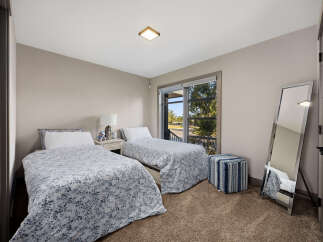 This charming bedroom features two twin beds with floral print comforters, perfect for guests or a shared space.