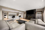 Experience modern luxury in this stunning living space, featuring a sleek gas fireplace set against a dramatic marble accent wall and a large flat-screen TV.