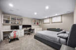 This modern bedroom features a spacious desk area with dual monitors and a gaming chair, perfect for work or play.