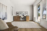 This home office features a modern aesthetic with a sleek wooden desk and a comfortable leather armchair.