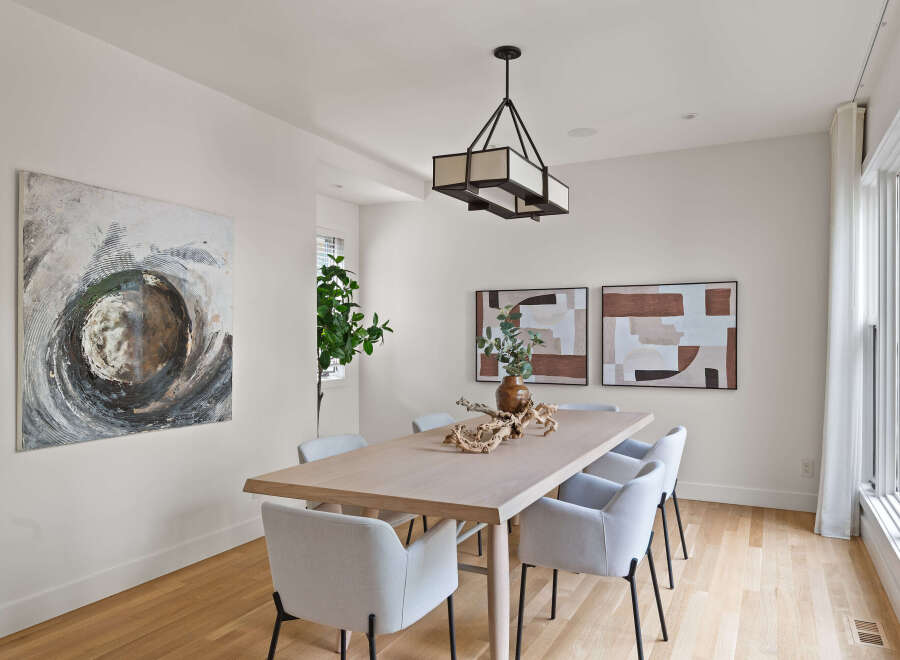 Elevate your dining experience in this elegant dining room, featuring a sleek wooden table and comfortable upholstered chairs.