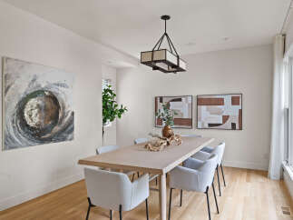Elevate your dining experience in this elegant dining room, featuring a sleek wooden table and comfortable upholstered chairs.