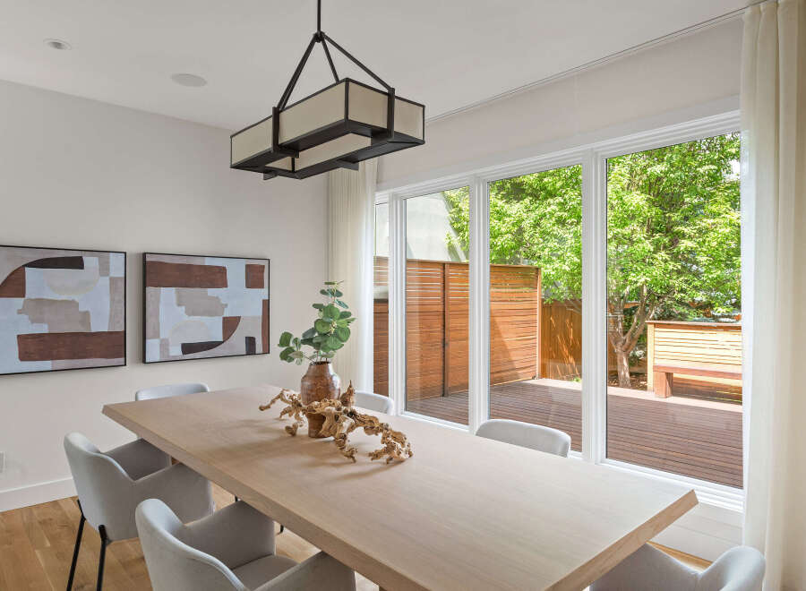 This modern dining room features a light wood dining table complemented by elegant upholstered chairs.