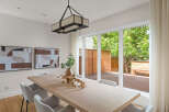 This modern dining room features a light wood dining table complemented by elegant upholstered chairs.