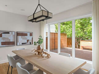 This modern dining room features a light wood dining table complemented by elegant upholstered chairs.