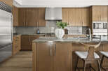 Experience luxury in this modern kitchen featuring sleek, custom wood cabinetry and a stunning granite island.