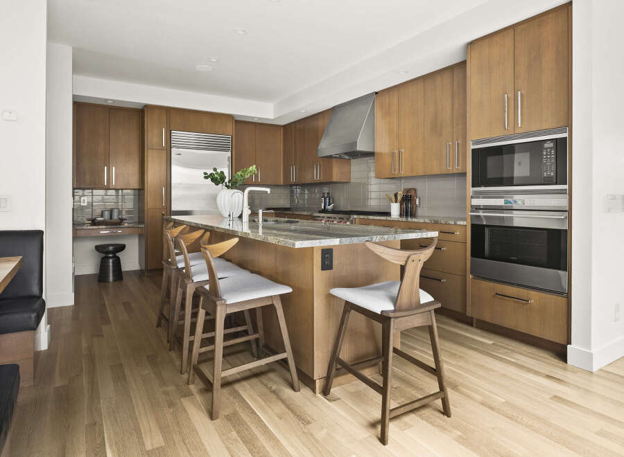 Experience luxury in this modern kitchen featuring sleek, custom wood cabinetry and a spacious granite island perfect for entertaining.
