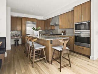 Experience luxury in this modern kitchen featuring sleek, custom wood cabinetry and a spacious granite island perfect for entertaining.