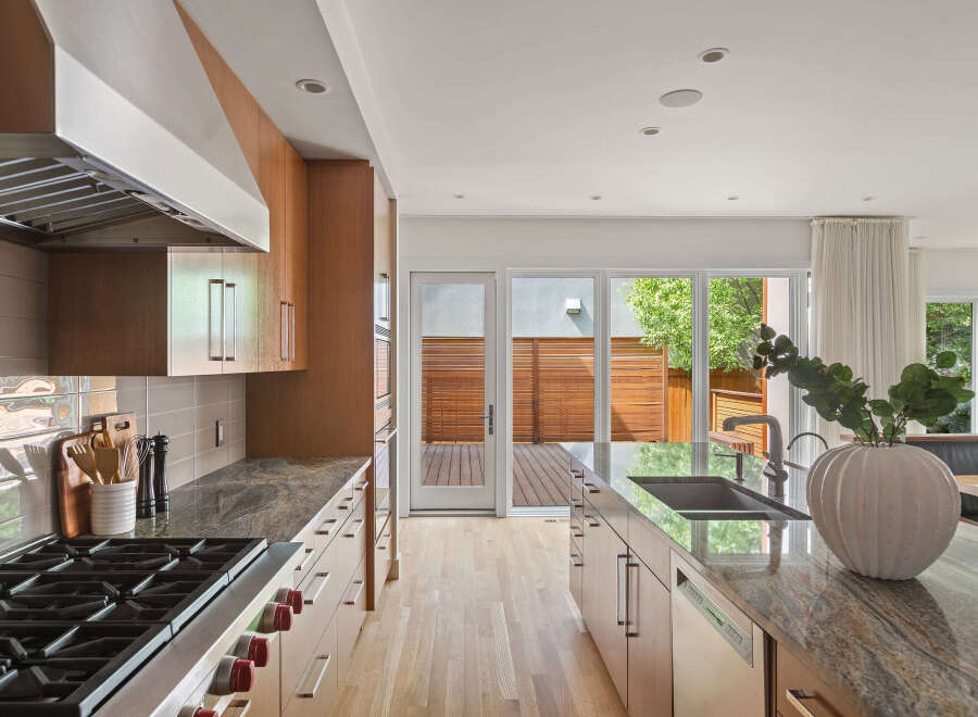Experience modern living in this stunning kitchen featuring sleek, custom wood cabinetry and luxurious granite countertops.