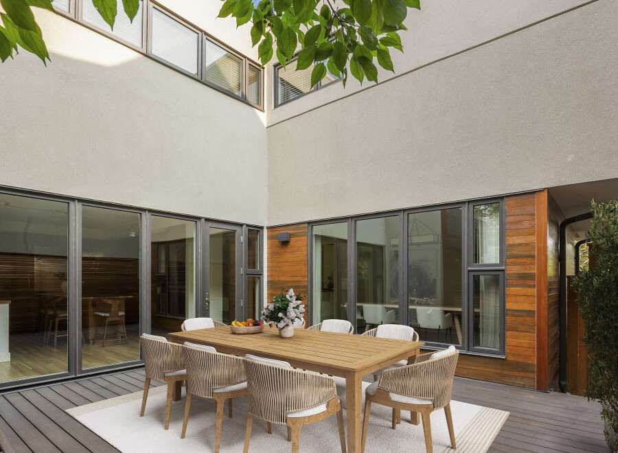 Experience seamless indoor-outdoor living with this stunning courtyard featuring a modern dining set.