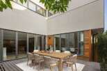 Experience seamless indoor-outdoor living with this stunning courtyard featuring a modern dining set.