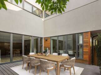 Experience seamless indoor-outdoor living with this stunning courtyard featuring a modern dining set.