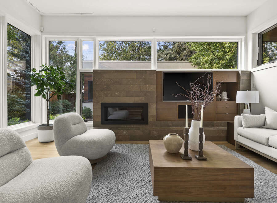 Experience modern living in this stunning living room, featuring a sleek fireplace with a stone accent wall and a built-in entertainment center.