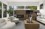 Experience modern living in this stunning living room, featuring a sleek fireplace with a stone accent wall and a built-in entertainment center.