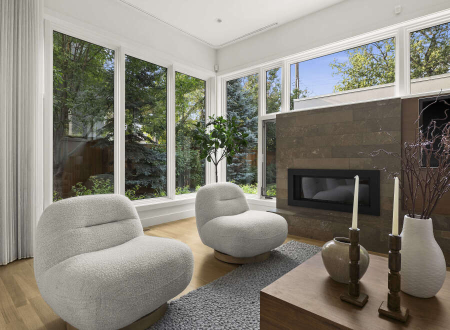 Experience modern living in this stunning living room, featuring a sleek fireplace and large windows that flood the space with natural light.