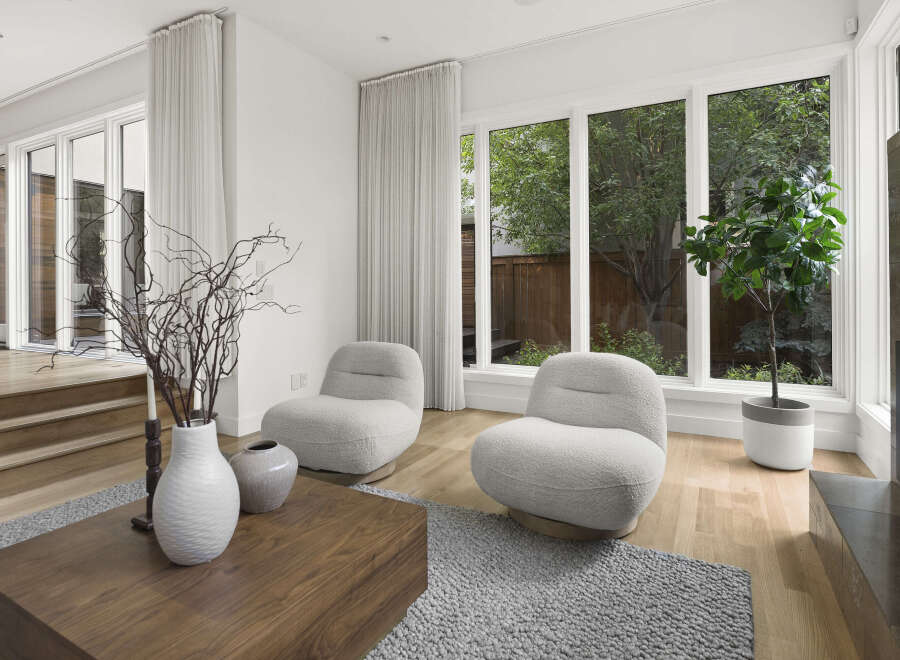 Experience modern living in this bright and airy living space, featuring plush boucle armchairs perfect for relaxation.
