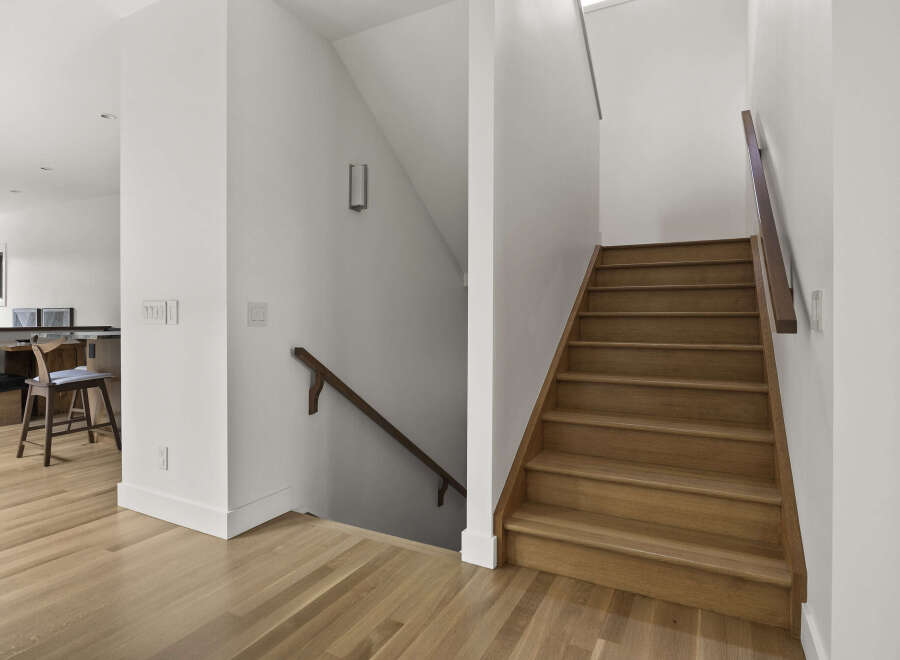 Step into this beautifully designed home featuring a modern staircase with warm wood treads and a sleek railing.
