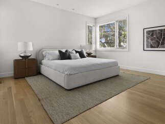 Experience modern comfort in this serene bedroom, featuring a plush, upholstered bed as the centerpiece.