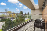 Enjoy breathtaking views from this modern balcony, featuring a sleek glass railing and comfortable outdoor seating.