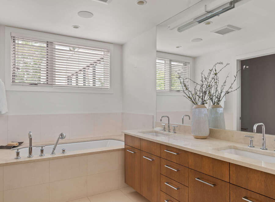 Experience luxury in this spacious bathroom featuring a deep soaking tub and a dual vanity with ample counter space.