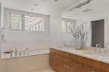 Experience luxury in this spacious bathroom featuring a deep soaking tub and a dual vanity with ample counter space.