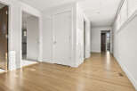 Step into this bright and airy hallway, featuring gleaming hardwood floors that reflect the natural light streaming through the blinds.