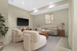 Experience modern living in this beautifully staged living room, featuring plush cream armchairs and a comfortable sofa perfect for relaxation.