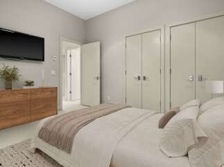 This modern bedroom features a sleek Samsung TV mounted above a stylish wooden dresser, perfect for entertainment.