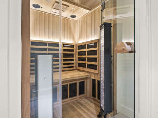 Experience ultimate relaxation in this luxurious infrared sauna, featuring a sleek glass door and natural wood interior.