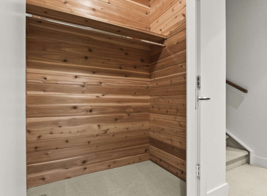 Step into this spacious cedar-lined walk-in closet, offering a natural and aromatic storage solution.