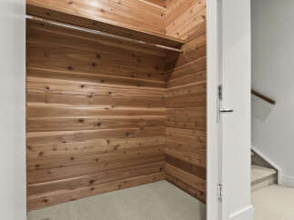 Step into this spacious cedar-lined walk-in closet, offering a natural and aromatic storage solution.