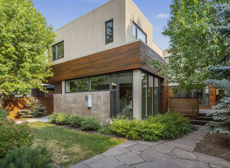 Discover modern living in this stunning home featuring a striking facade with a blend of stucco and warm wood accents.