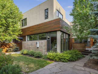Discover modern living in this stunning home featuring a striking facade with a blend of stucco and warm wood accents.