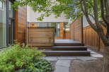 Experience modern outdoor living with this beautifully designed backyard featuring a spacious wooden deck and a privacy screen.