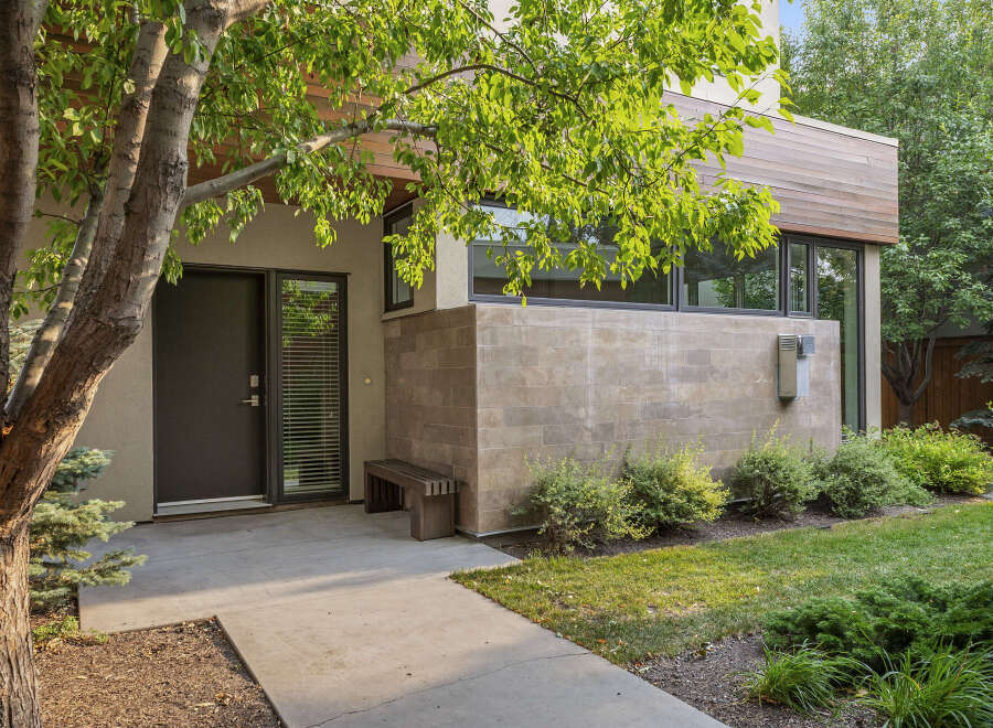 Discover modern living with this stunning home featuring a sleek facade of wood and stone.