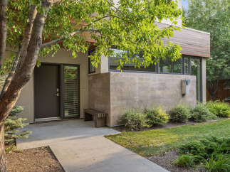 Discover modern living with this stunning home featuring a sleek facade of wood and stone.