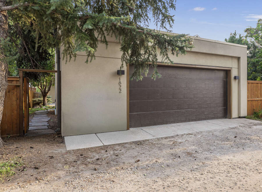 Discover this modern garage with a sleek, dark brown door and a clean, stucco exterior.