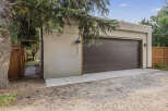 Discover this modern garage with a sleek, dark brown door and a clean, stucco exterior.