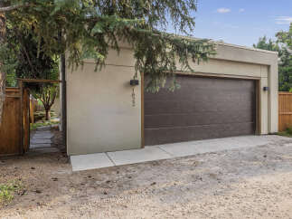 Discover this modern garage with a sleek, dark brown door and a clean, stucco exterior.