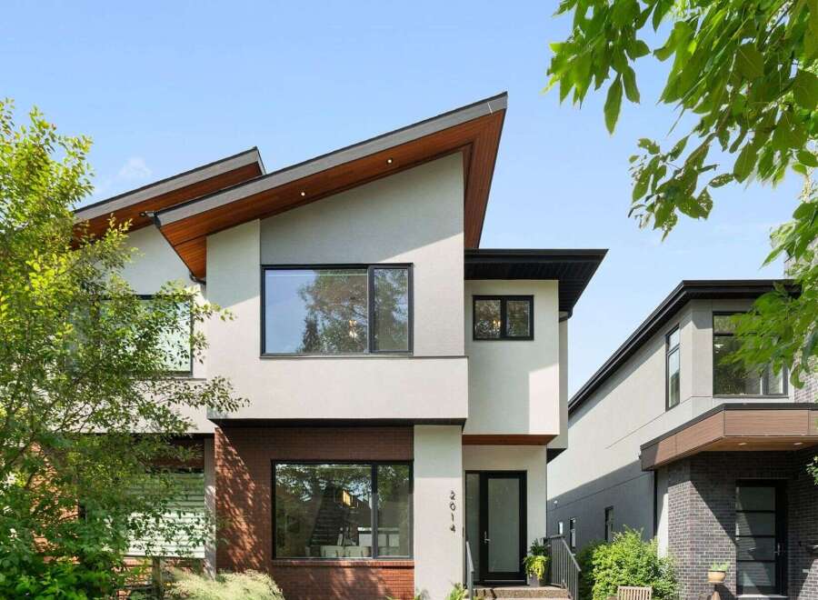 Discover modern architectural brilliance with this stunning home featuring a unique, asymmetrical roofline and a striking blend of stucco and brick exterior.